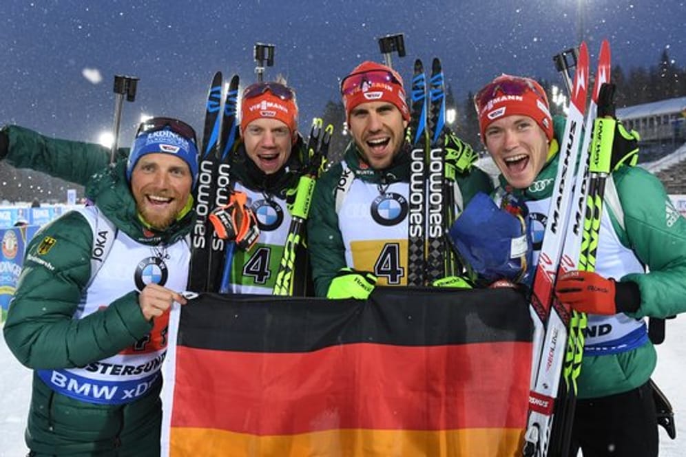 Erik Lesser (l-r-), Roman Rees, Arnd Peiffer und Benedikt Doll freuen sich mit einer deutschen Fahne über den zweiten Platz.