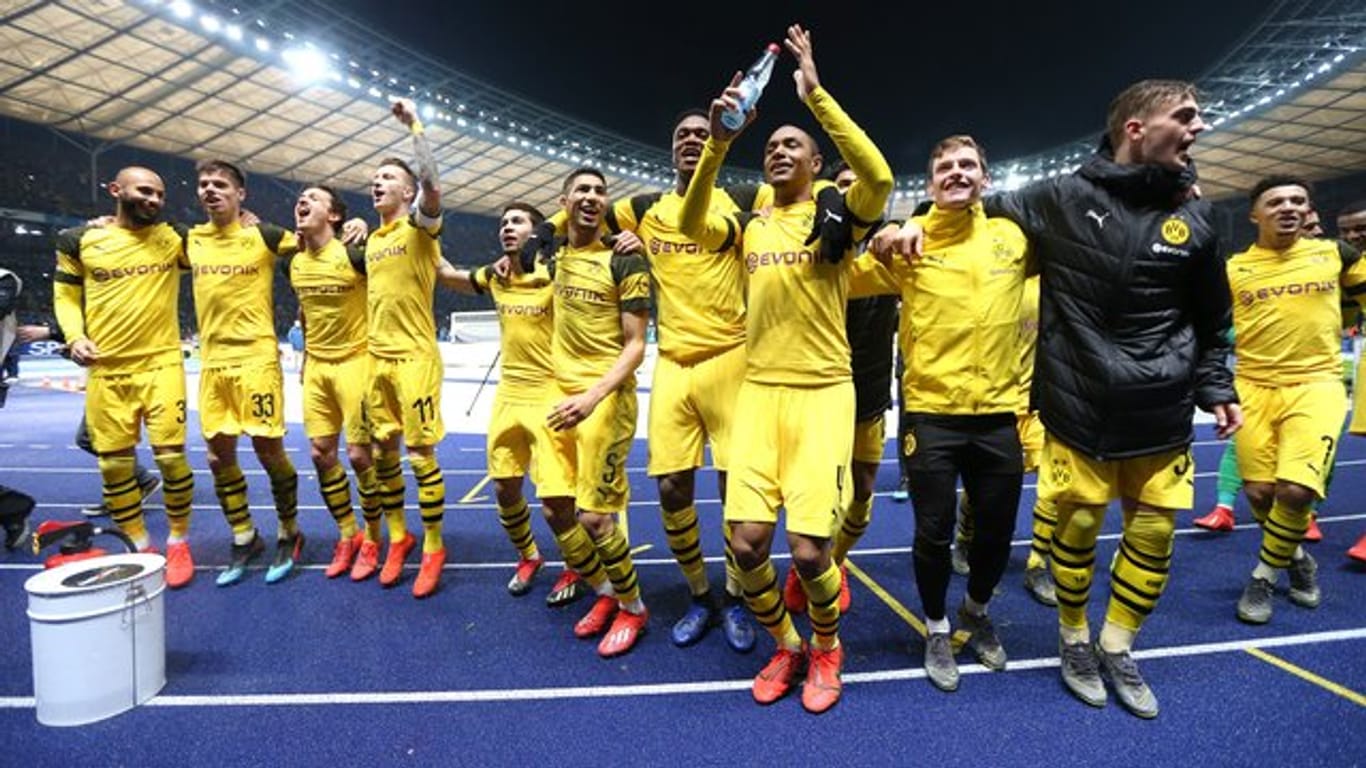 Die Spieler von Borussia Dortmund feiern den Last-Minute-Sieg in Berlin vor ihrer Fankurve.