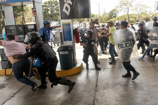 Polizisten gehen an einer Tankstelle in Managua gegen Demonstranten vor.