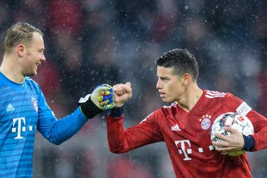 Dreifachtorschütze James Rodríguez (r) feiert mit Torwart Manuel Neuer den Sieg des FC Bayern München.