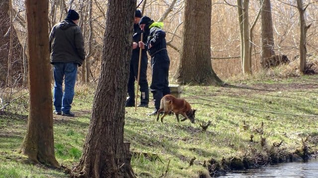 Polizeibeamte mit einem Spürhund suchen am Ufer des Storkower Kanals nahe dem Wolziger See im Landkreis Dahme-Spreewald nach der vermissten Rebecca.