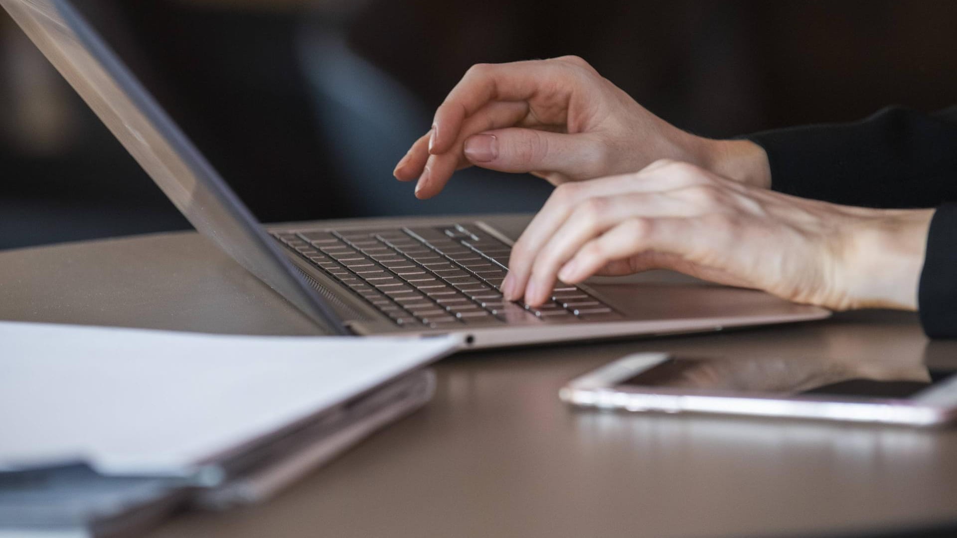 Laptop und Handy auf einem Schreibtisch