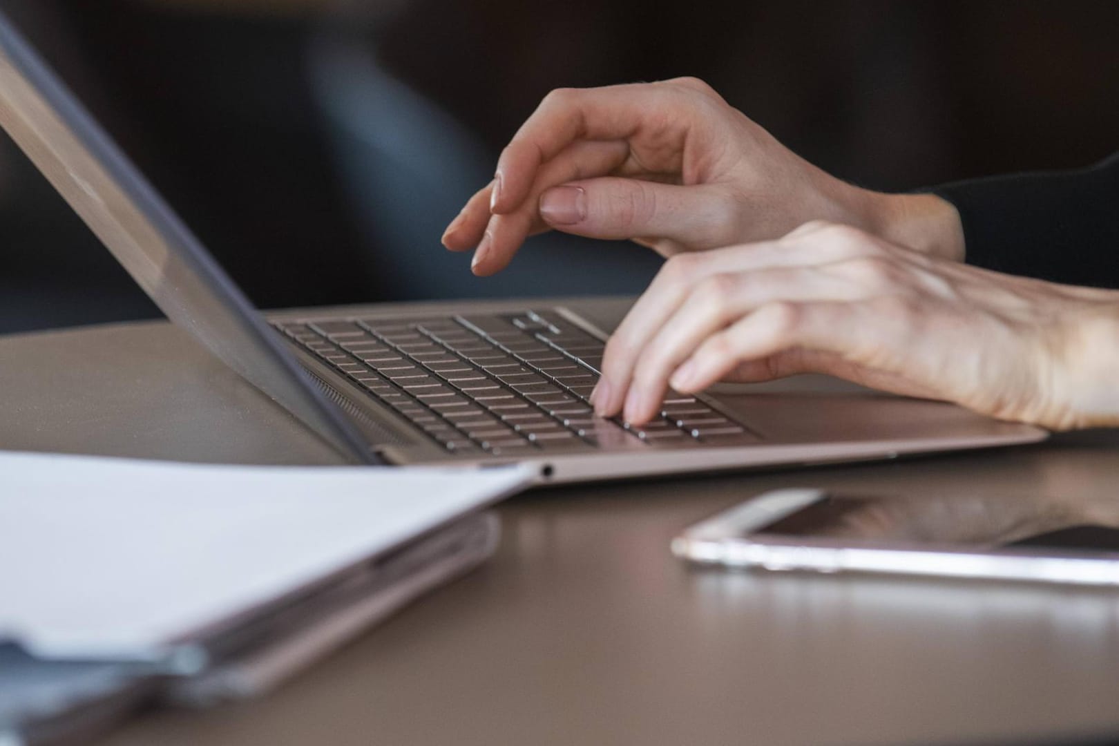 Laptop und Handy auf einem Schreibtisch