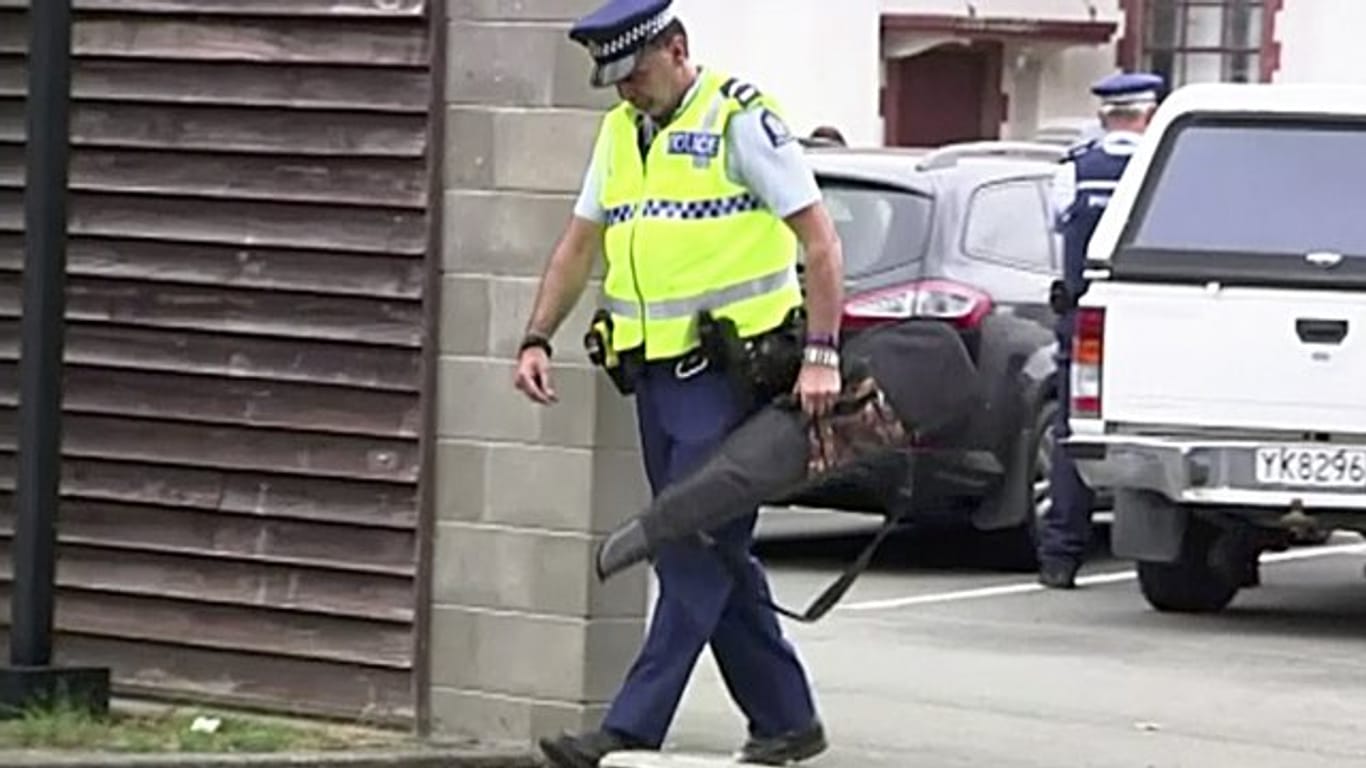 Videostandbild eines Polizisten, der eine Waffe trägt, die von einem Bürger freiwillig in einer Polizeistation abgegeben wurde.
