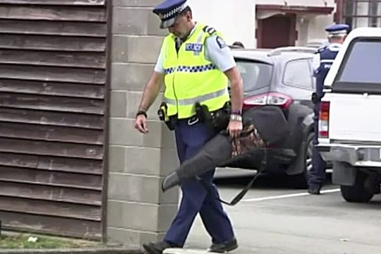 Videostandbild eines Polizisten, der eine Waffe trägt, die von einem Bürger freiwillig in einer Polizeistation abgegeben wurde.