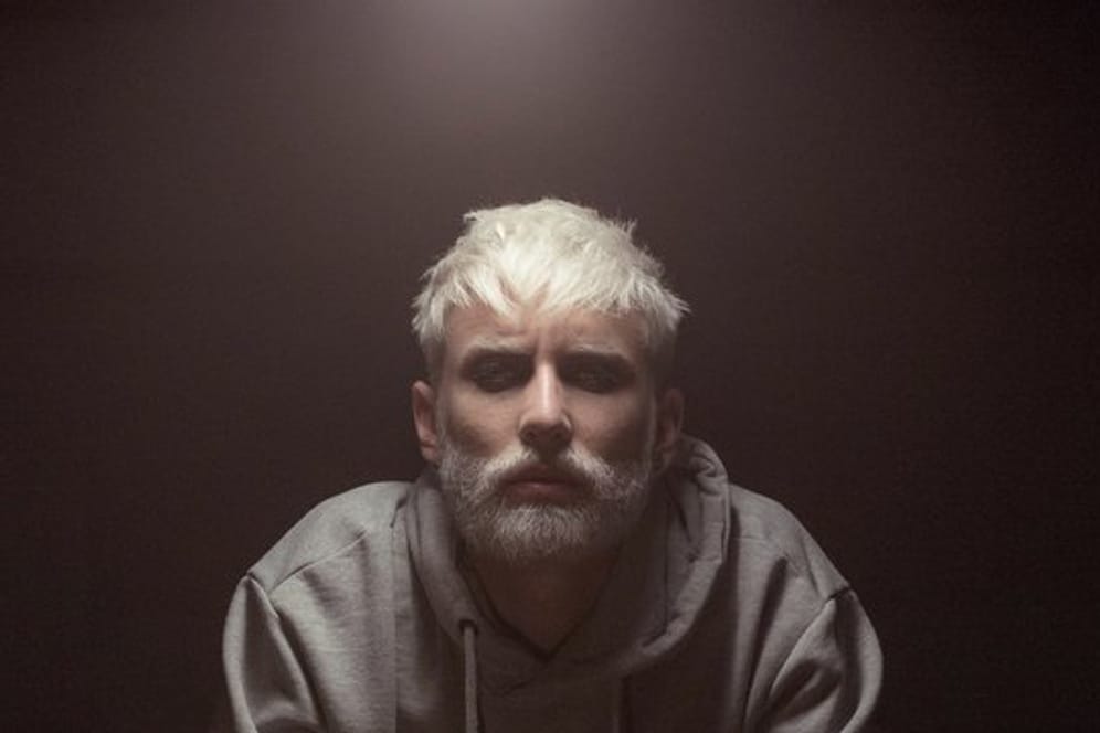 Tom Neuwirth jetzt mit blondem Bart und Kurzhaarfrisur wirbt für das Musikprojekt Wurst.