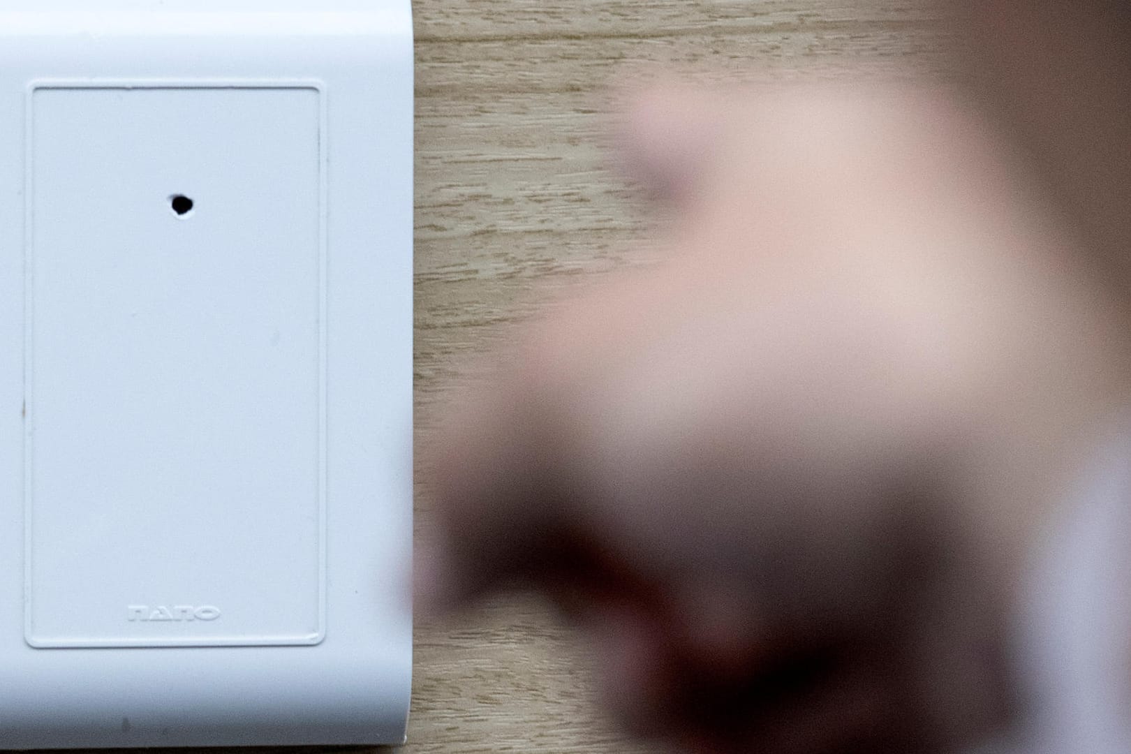 Ein Polizist demonstriert eine der Überwachungskameras: Überwachungskameras mit millimetergroßen Objektiven in Fön-Halterungen, Steckdosenabdeckungen und Digitalfernsehempfängern waren in den Motels installiert.