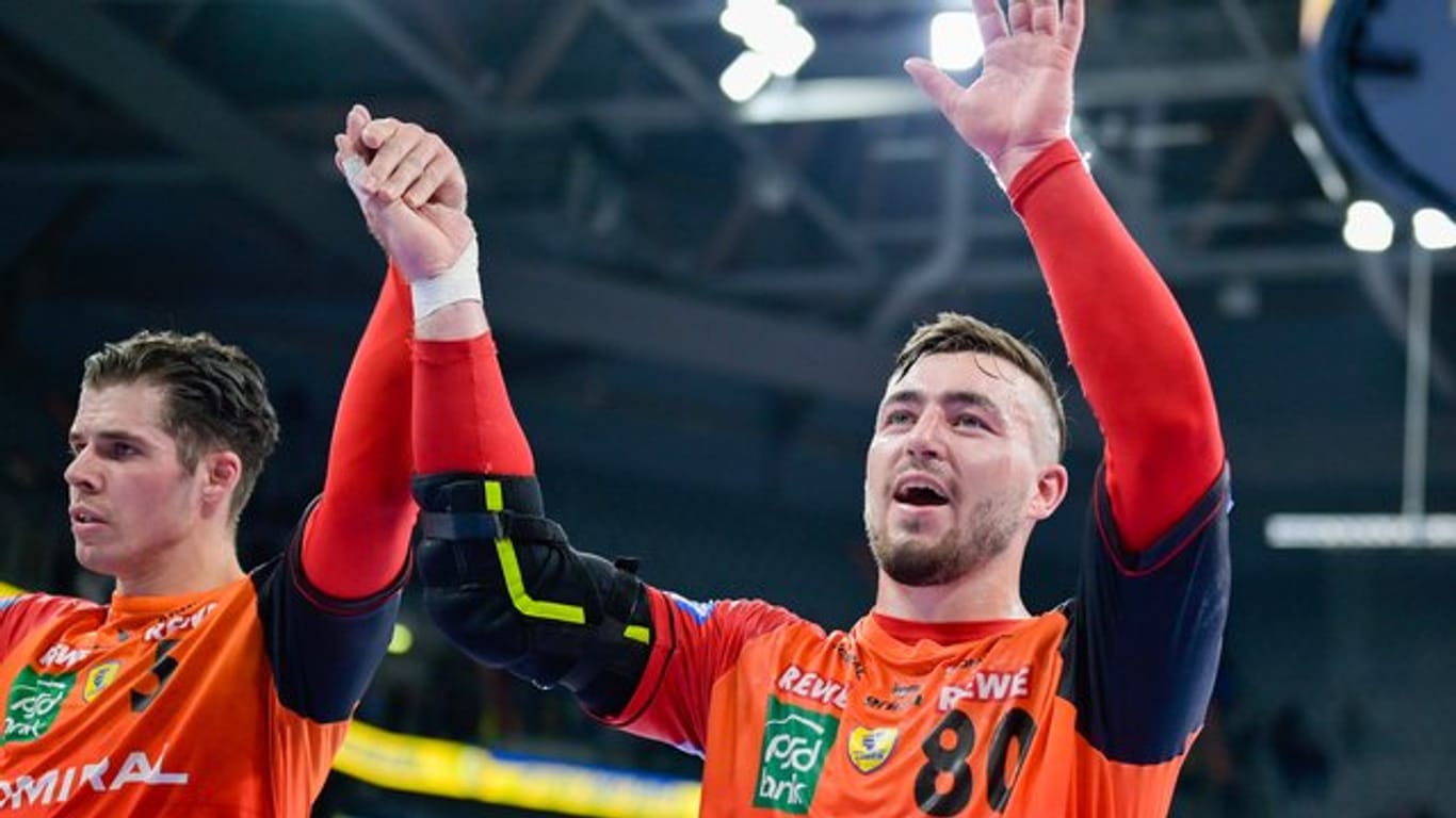Jannik Kohlbacher (r) und Vladan Lipovina von den Rhein-Neckar Löwen feiern den Sieg gegen Nantes.