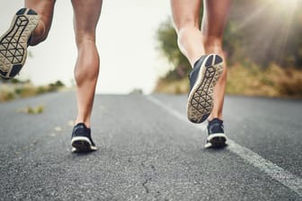 Fitnessmythen hinterfragt: Zwei Jogger laufen über den Asphalt – schadet Laufen den Knien?