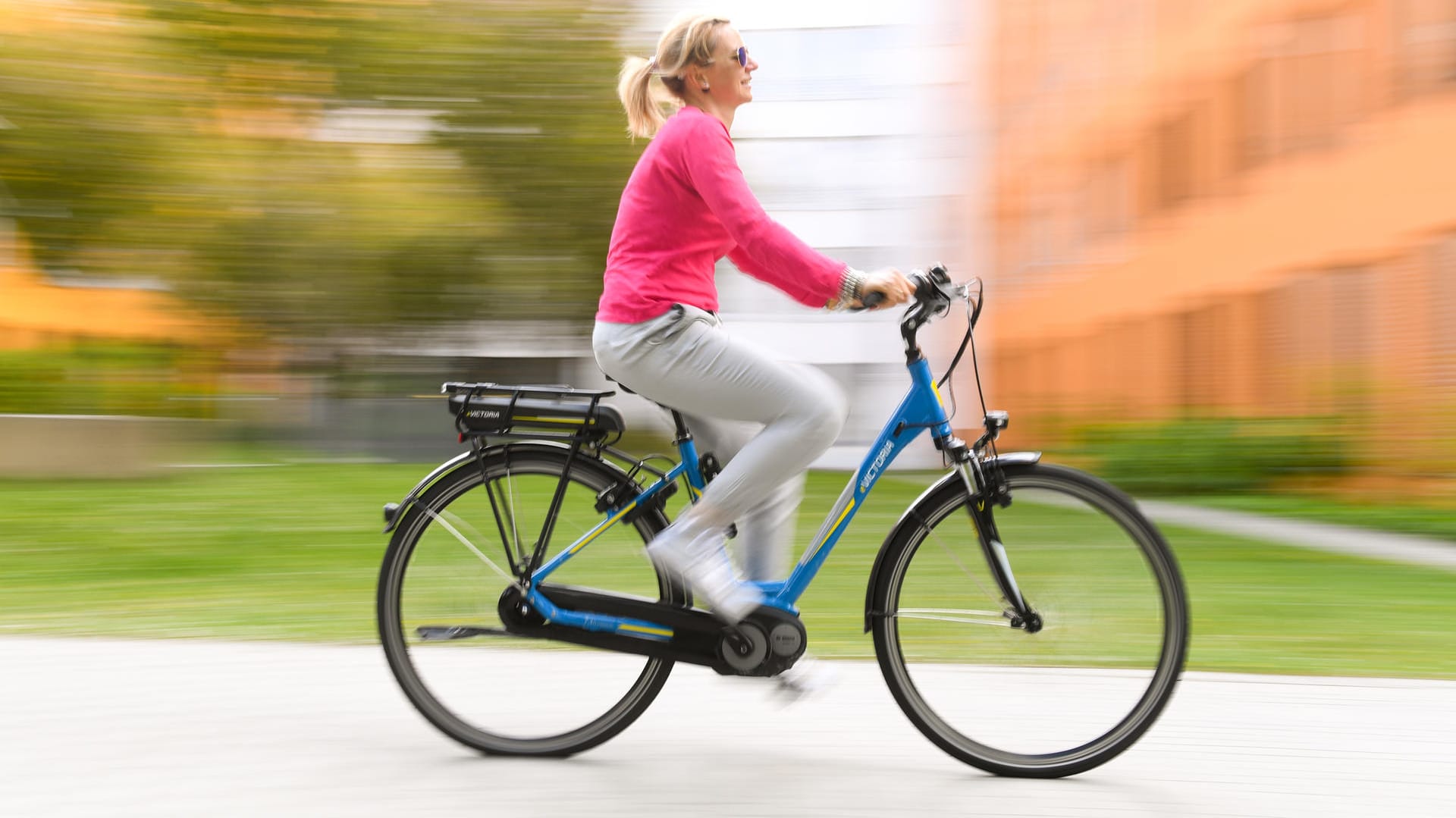 Frau auf einem Pedelec: Bevor es in den Straßenverkehr geht, sollte die Fahrdynamik des motorisierten Fahrrads auf einer hindernisfreien Fläche getestet werden.