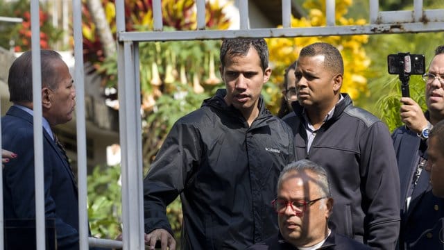 Juan Guaidó (M) in der Nähe des Hauses seines Bürochefs Marrero.