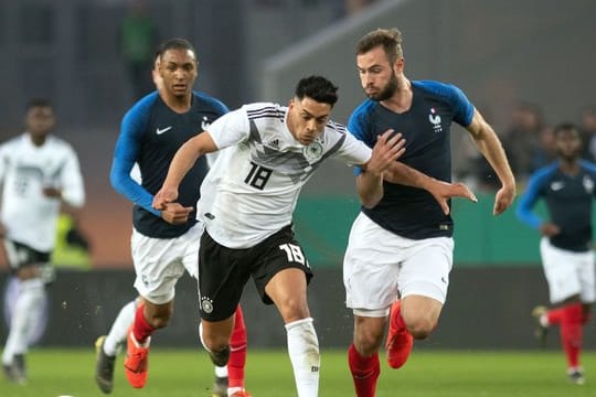 DFB-Akteur Nadiem Amiri (M) versucht dem Franzosen Lucas Tousart zu enteilen.