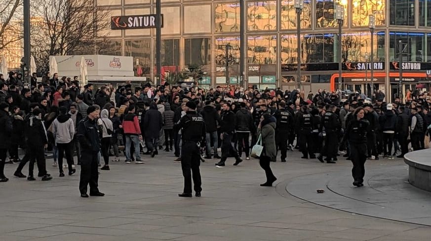 Berliner Alexanderplatz: Polizisten vor einer großen Menge von Jugendlichen.