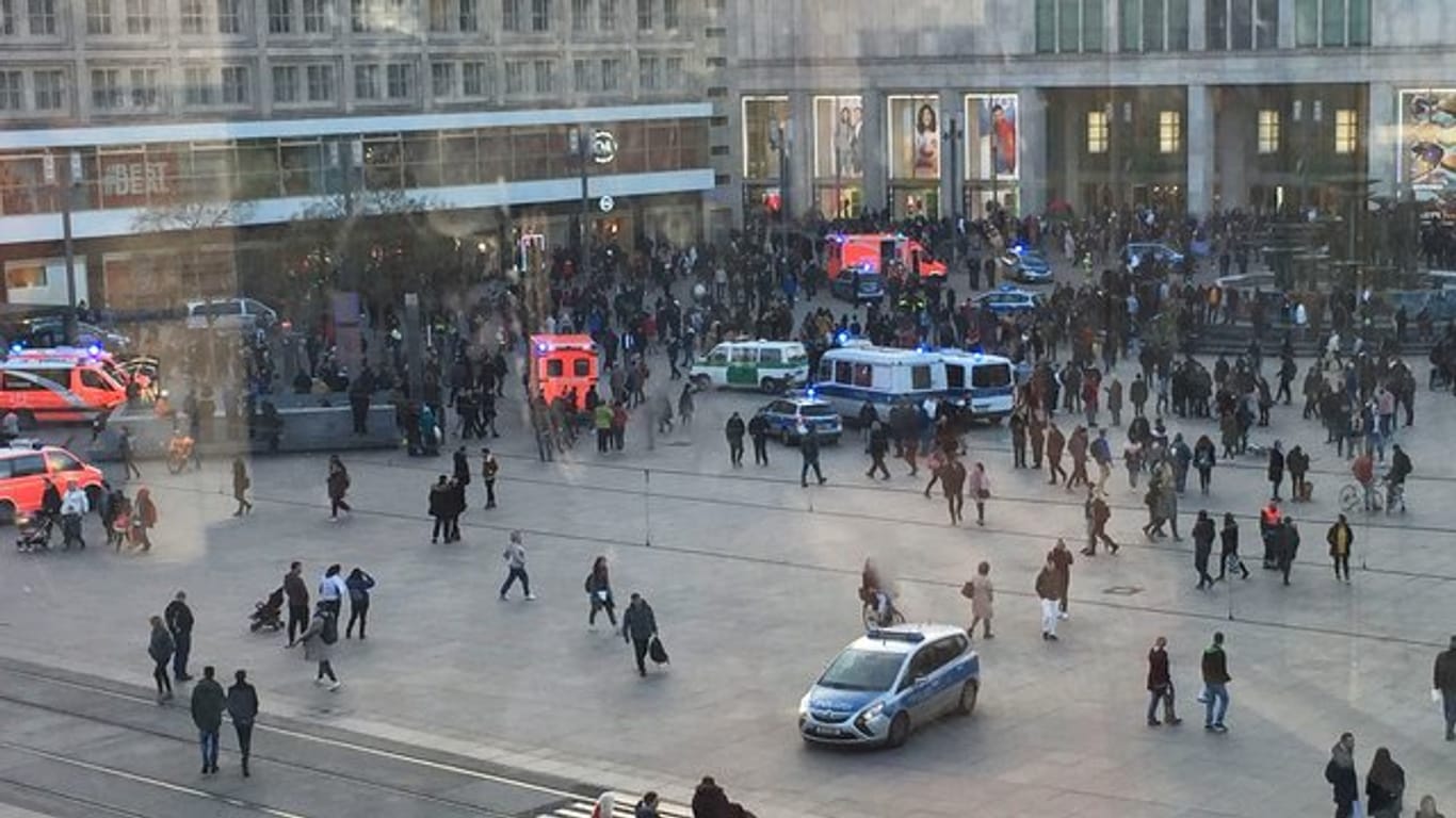 Menschengruppen, Polizeifahrzeuge und Krankenwagen stehen auf dem Alexanderplatz.