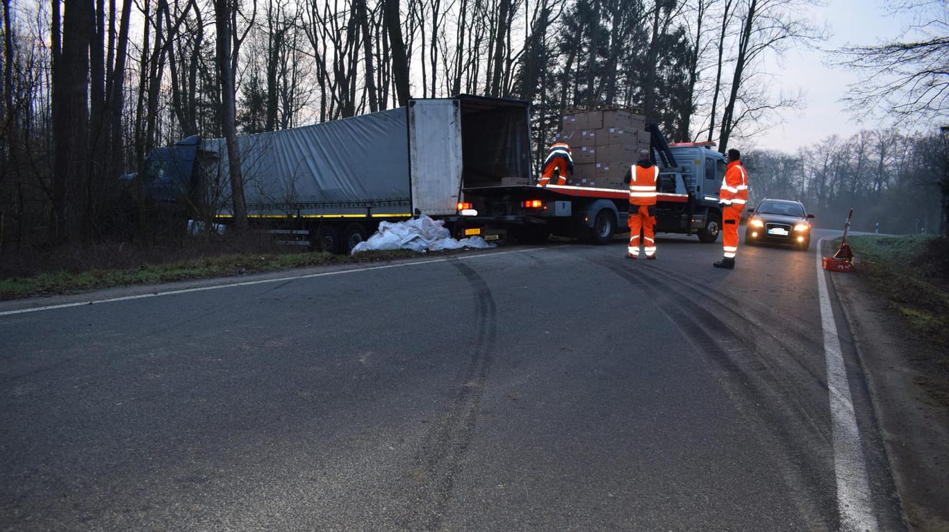Niedersachsen, Reinsdorf: Rettungskräfte bergen die Ladung eines Lkw, der nach einem Unfall in einem Waldstück steht.