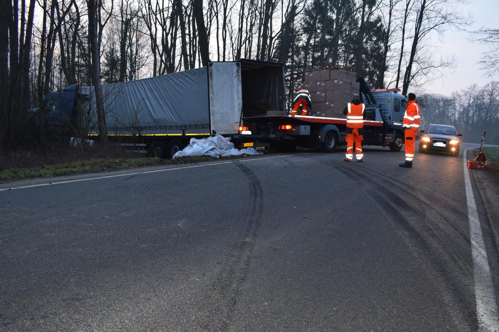 Niedersachsen, Reinsdorf: Rettungskräfte bergen die Ladung eines Lkw, der nach einem Unfall in einem Waldstück steht.