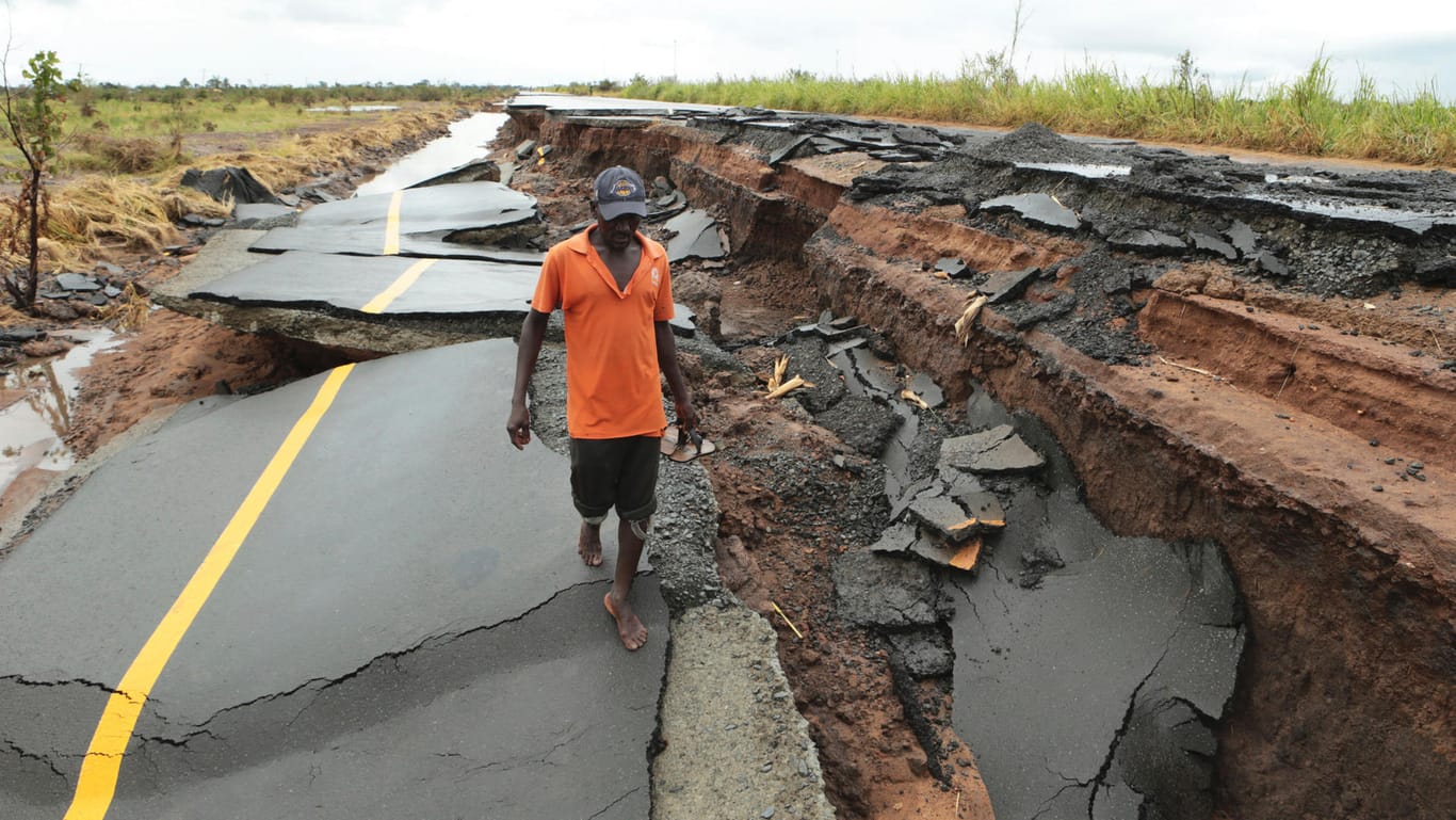 Mosambik, Beira: Ein Mann überquert eine vom Zyklon "Idai" zerstörte Straße in Nhamatanda, etwa 50 Kilometer von Beira entfernt.