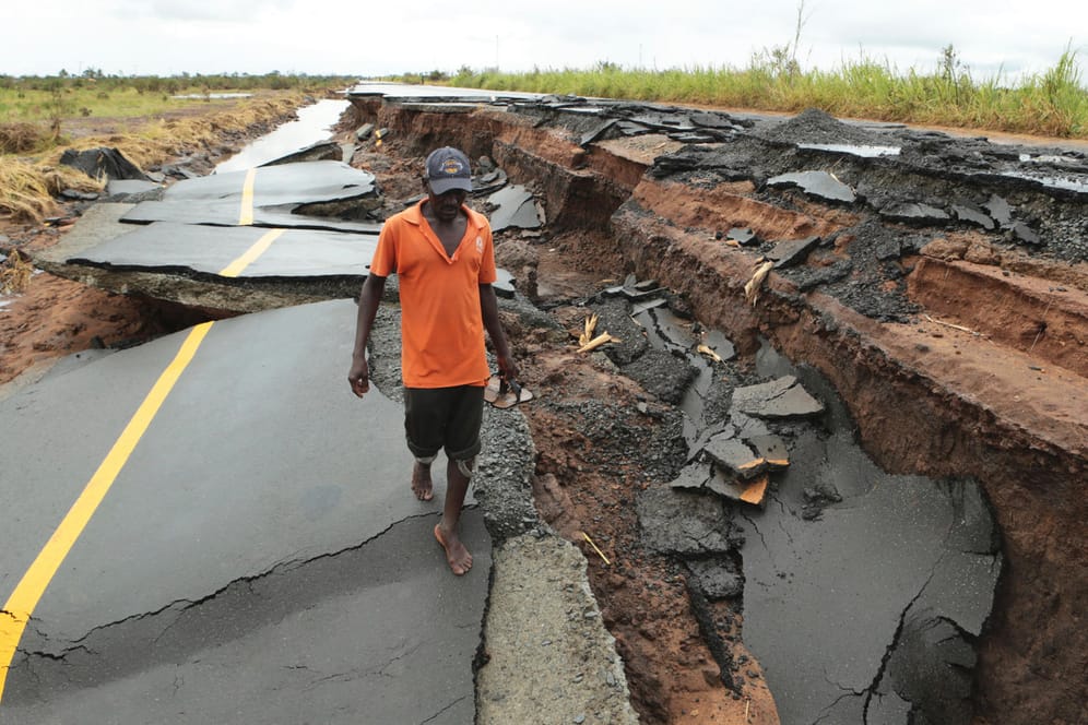 Mosambik, Beira: Ein Mann überquert eine vom Zyklon "Idai" zerstörte Straße in Nhamatanda, etwa 50 Kilometer von Beira entfernt.