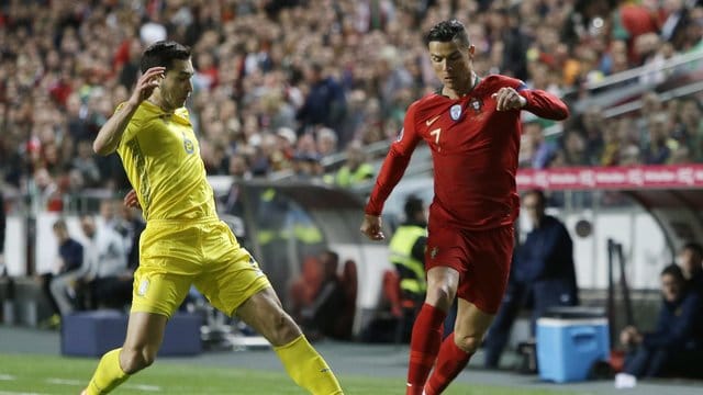 Portugals Superstar Cristiano Ronaldo (r) wird vom Ukrainer Taras Stepanenko unter Druck gesetzt.