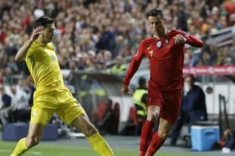 Portugals Superstar Cristiano Ronaldo (r) wird vom Ukrainer Taras Stepanenko unter Druck gesetzt.