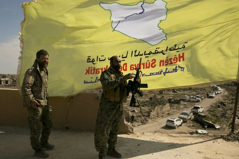 Kämpfer der von den USA unterstützten Syrischen Demokratischen Kräfte (SDF) hissen ihre Flagge über Baghus.
