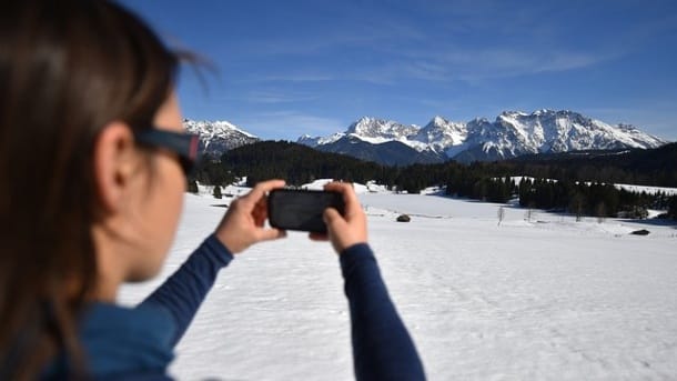 Fototourismus: Eine Frau fotografiert den mit Eis bedeckten Geroldsee vor dem Karwendel-Gebirge.