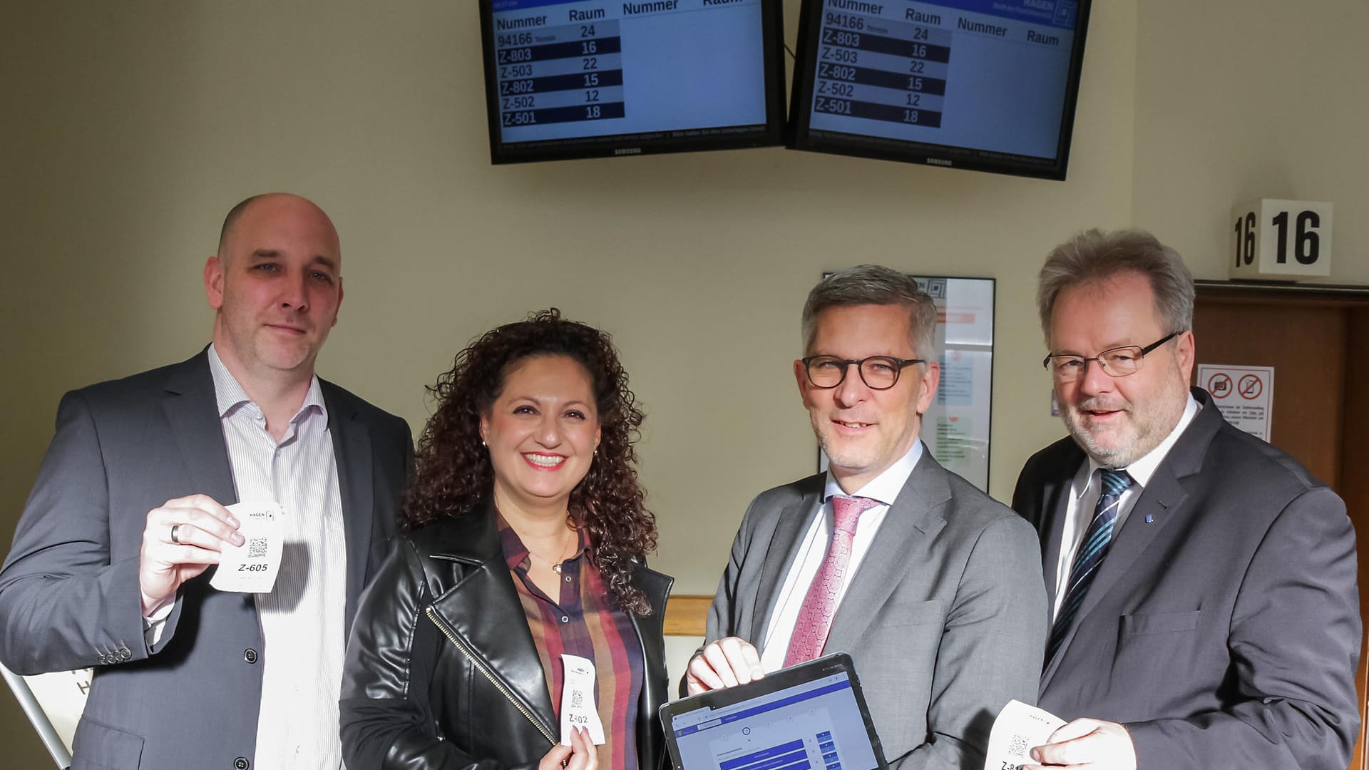 Freude über moderne Technik in der Zulassungsstelle Hohenlimburg: Christian Lazar (Leiter Task Force Digitalisierung), Edibe Yilmaz (stellv. Leiterin Zulassungsbehörde), OB Erik O. Schulz und der Beigeordnete Thomas Huyeng.