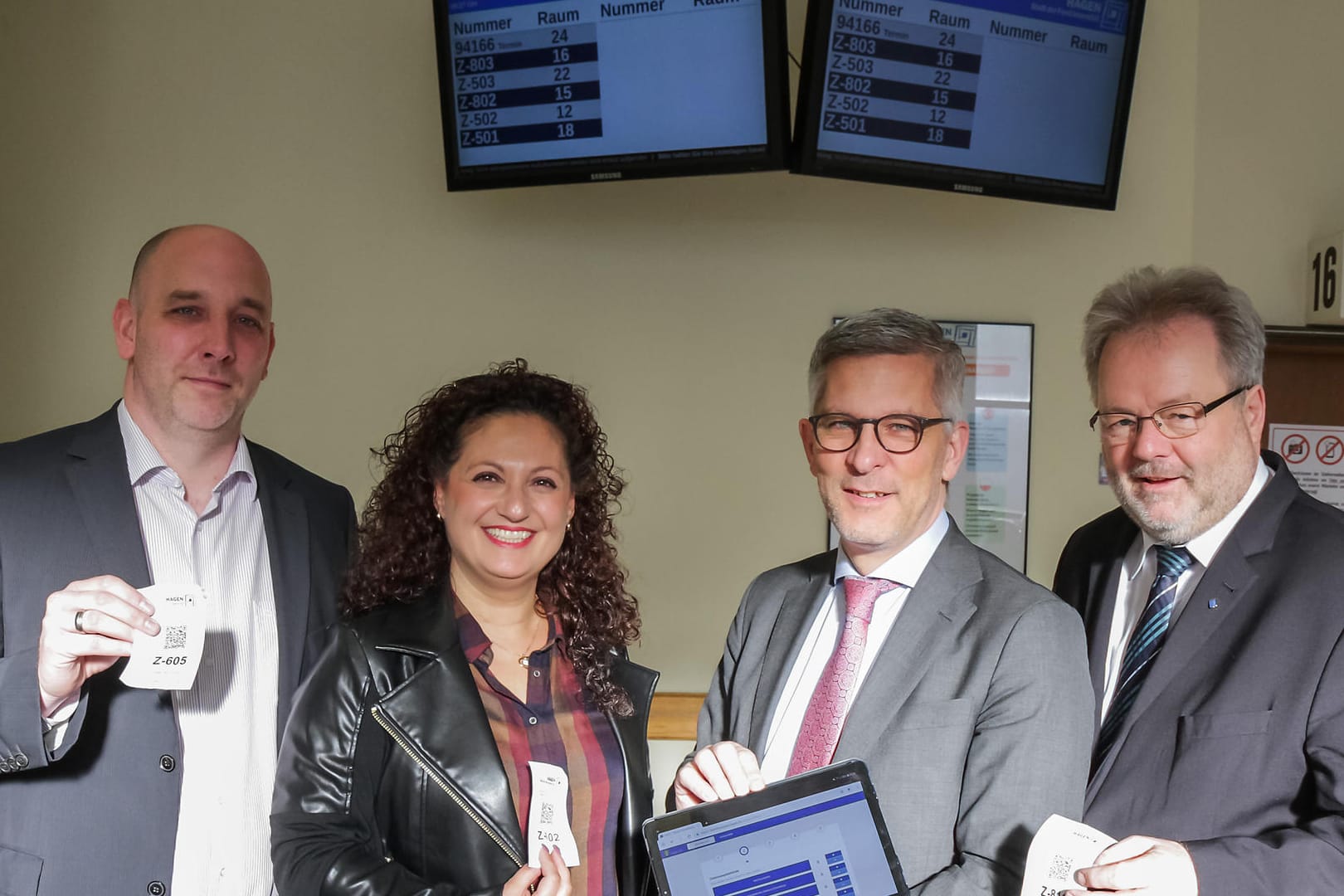 Freude über moderne Technik in der Zulassungsstelle Hohenlimburg: Christian Lazar (Leiter Task Force Digitalisierung), Edibe Yilmaz (stellv. Leiterin Zulassungsbehörde), OB Erik O. Schulz und der Beigeordnete Thomas Huyeng.