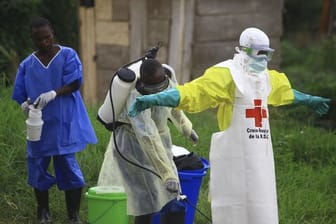 Helfer reinigen sich nach der Arbeit in einem Behandlungszentrum gegen Ebola mit Desinfektionsmittel: Es überleben nun rund 60 Prozent der Menschen, die in ein Behandlungszentrum eingeliefert werden.