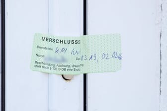 Verschlusssiegel der Würzburger Polizei an der Tür einer im Kinderporno-Fall durchsuchten Wohnung.