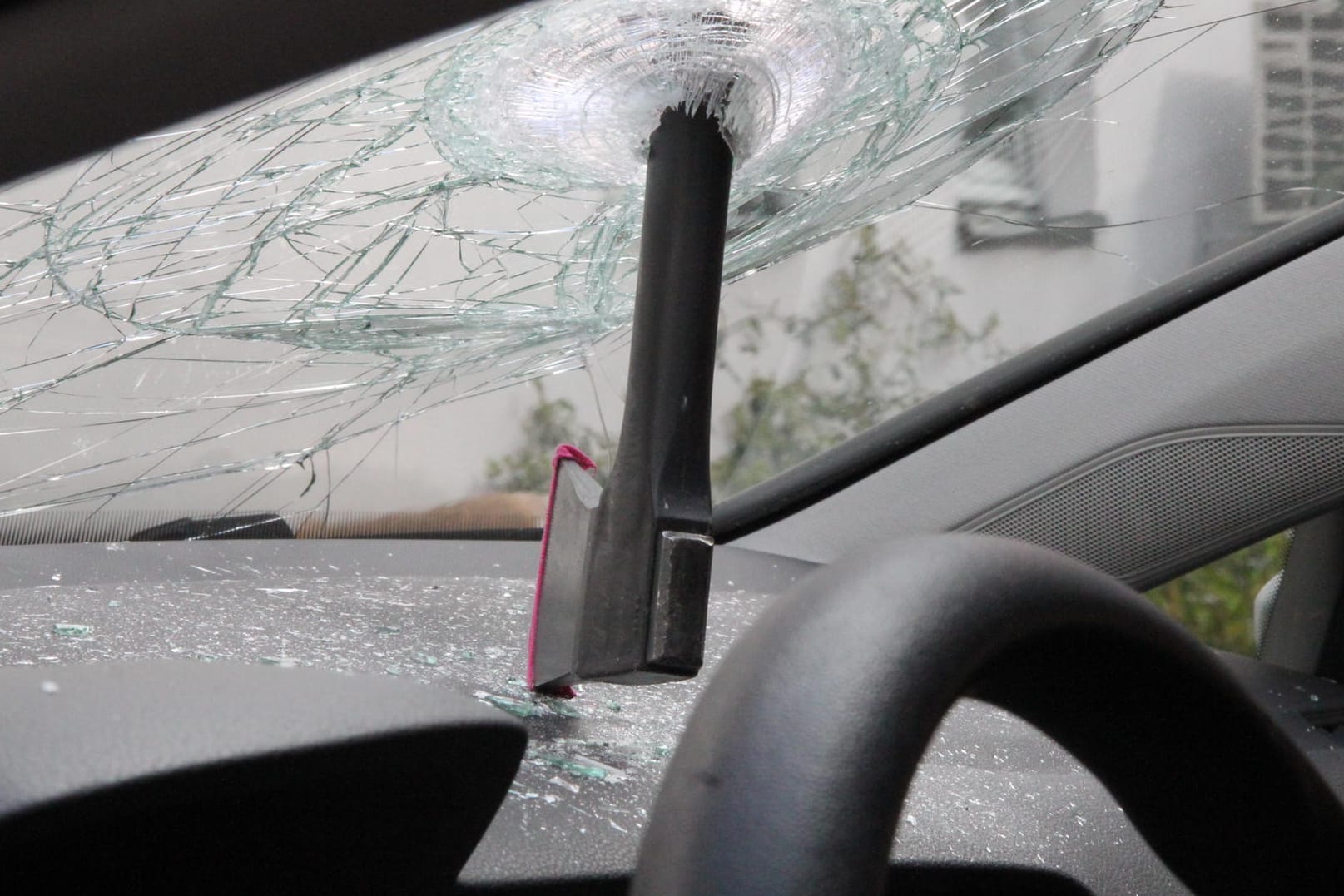 Eine Axt steckt in der Windschutzscheibe eines Polizeiautos: Der verantwortliche Mann stand demnach unter dem Einfluss von Drogen und war betrunken.