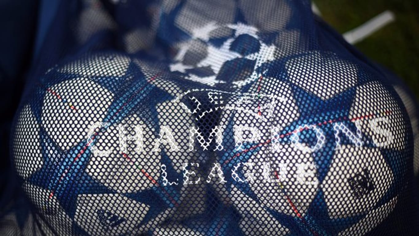 Bälle mit dem Logo der UEFA Champions League liegen in einem Netz.