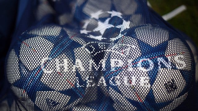 Bälle mit dem Logo der UEFA Champions League liegen in einem Netz.