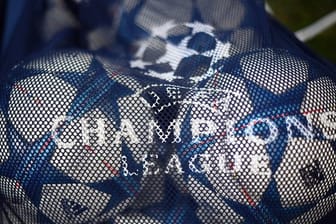Bälle mit dem Logo der UEFA Champions League liegen in einem Netz.