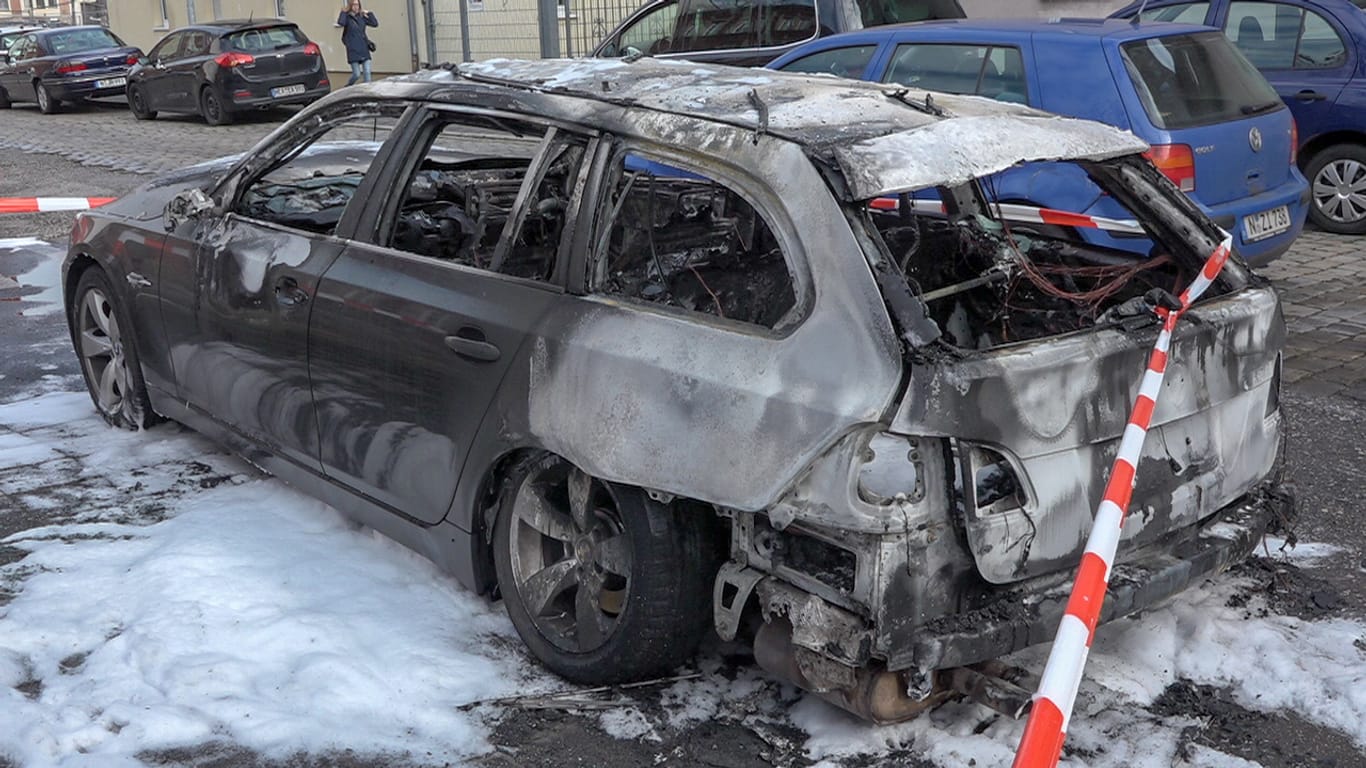 Ein ausgebranntes Fahrzeug steht auf einer Straße: Trotz des Feuerwehreinsatzes brannte das Auto komplett aus, der Sachschaden liegt bei rund 10.000 Euro.