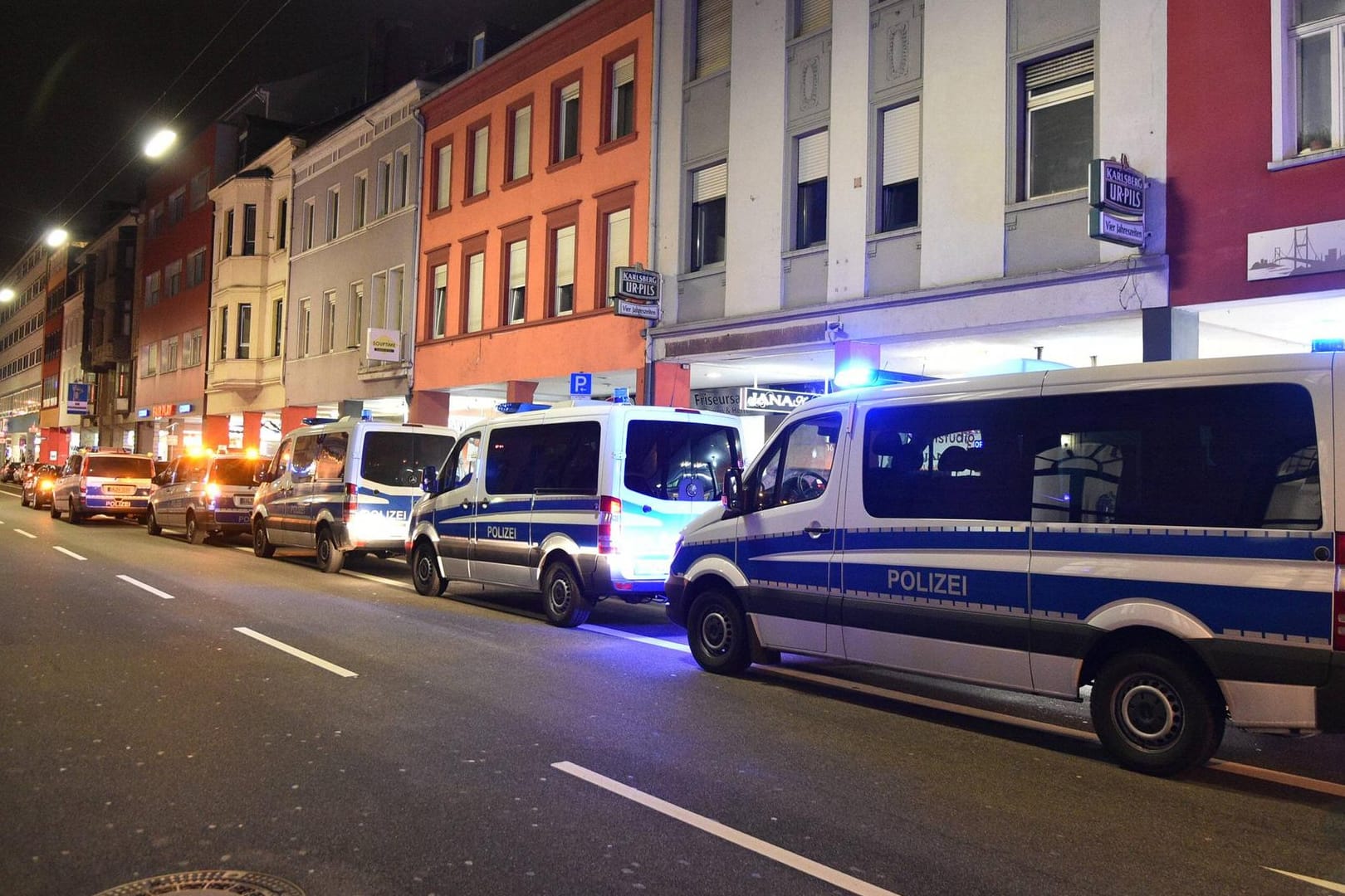 Drei Einsatzwagen parken hintereinander bei einer Polizei-Razzia (Symbolfoto): An der Razzia an 40 Orten waren fast 200 Steuerfahnder und Polizeibeamte beteiligt.