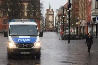 Ein Polizeifahrzeug ist in der menschenleeren Kröpeliner Straße zu sehen.