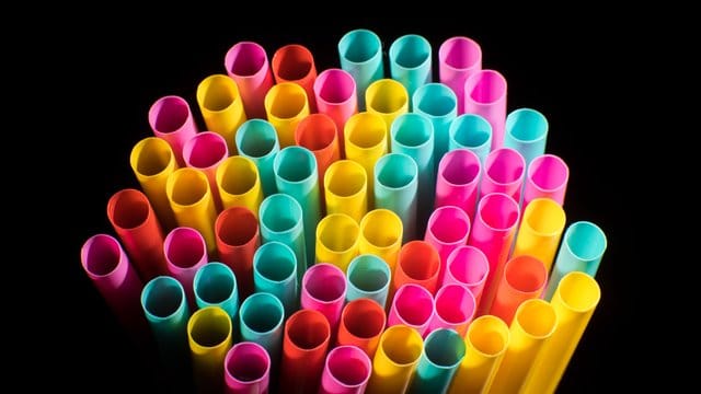 Trinkhalme aus Plastik liegen auf einem Tisch.