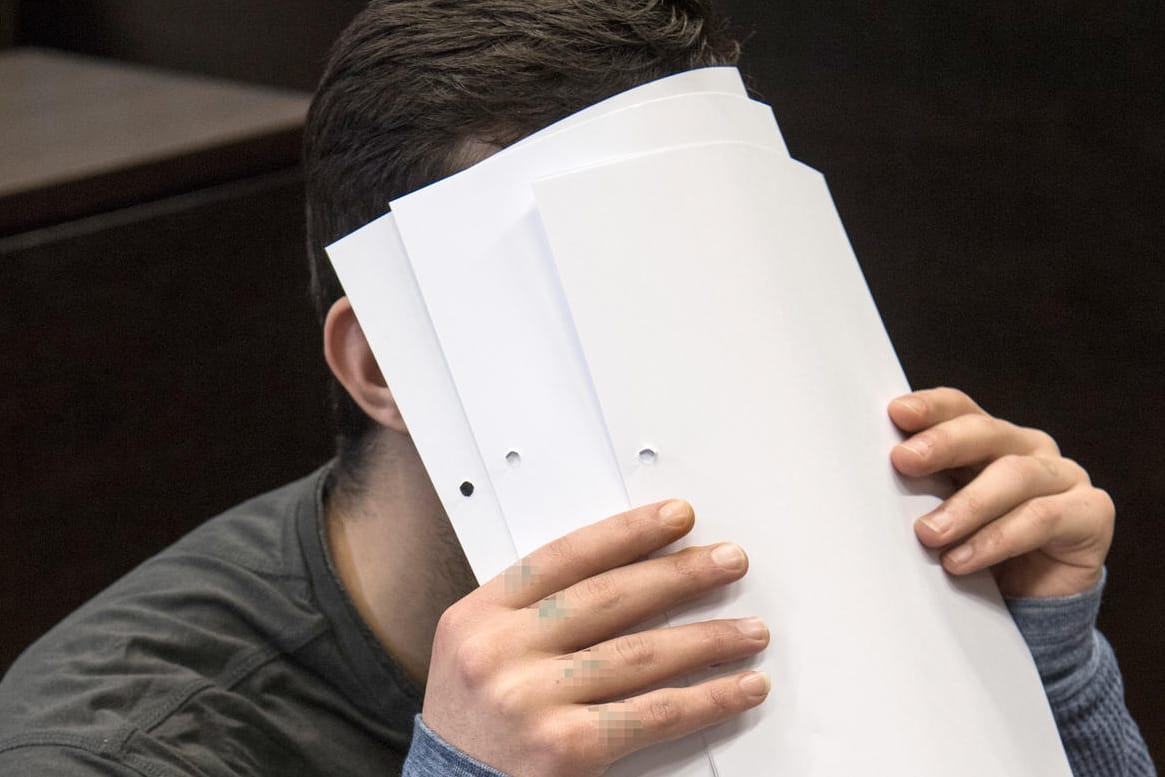 Ali B.: Mit Zetteln verdeckt der Angeklagte sein Gesicht vor den Kameras der Journalisten.