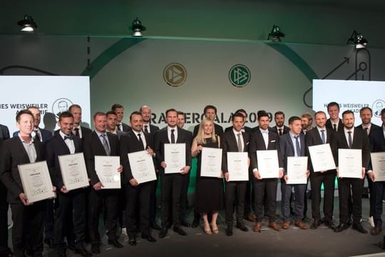 Die Trainer des Fußballlehrer-Lehrgangs stehen mit DFB-Präsident Reinhard Grindel (l) beim Gruppenfoto zusammen.