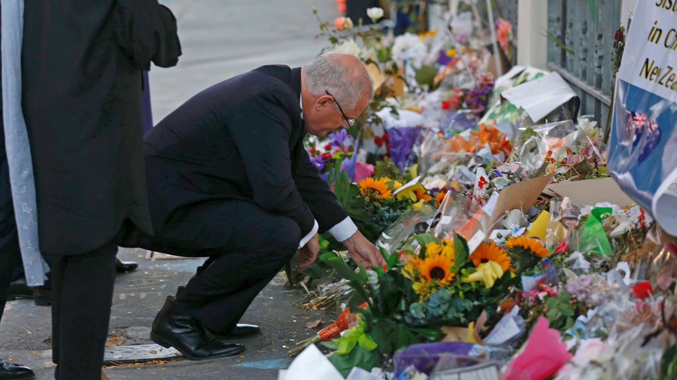 Nach Terroranschlag in Neuseeland: Der australische Premierminister Scott Morrison hält bei seiner Ankunft zum nationalen Gedenkgottesdienst für die Opfer des Terroranschlages vor den niedergelegten Blumen inne