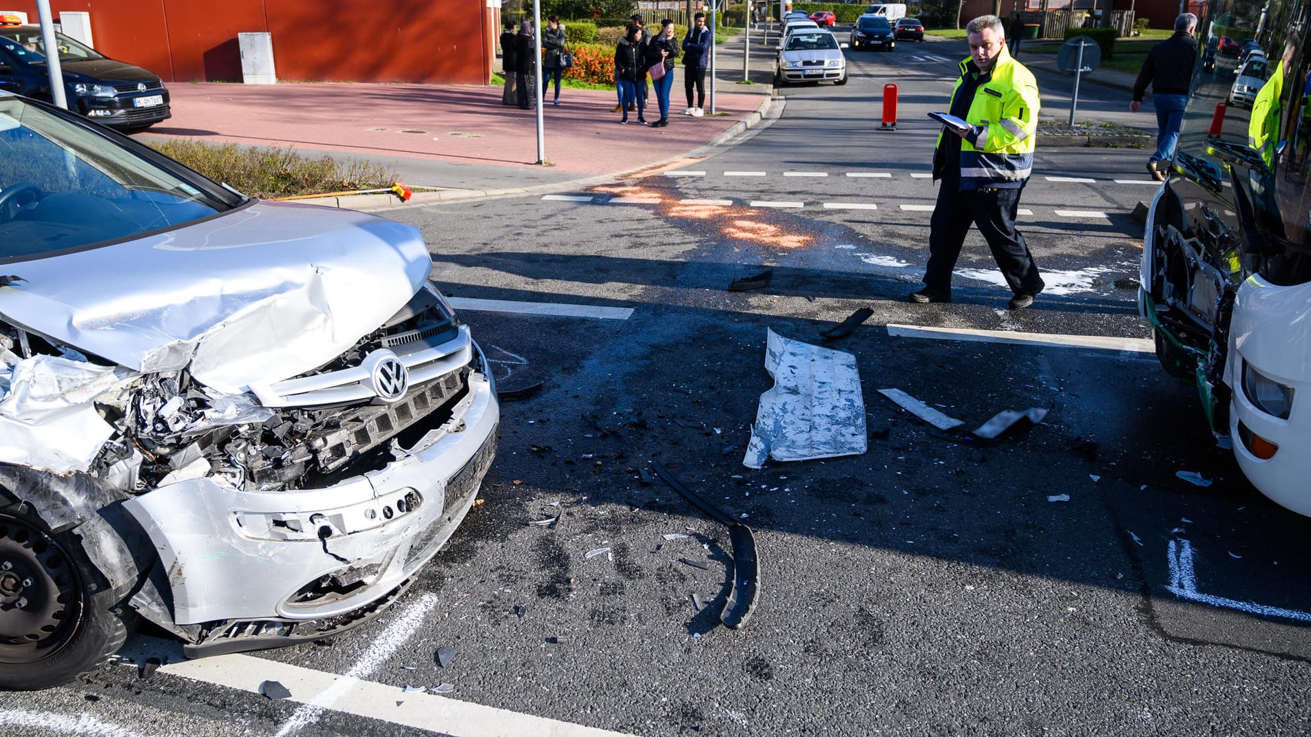 Ein beschädigtes Auto und ein Schulbus stehen an einer Unfallstelle: Insgesamt befanden sich rund 30 Insassen in dem Bus, vor allem Schüler.