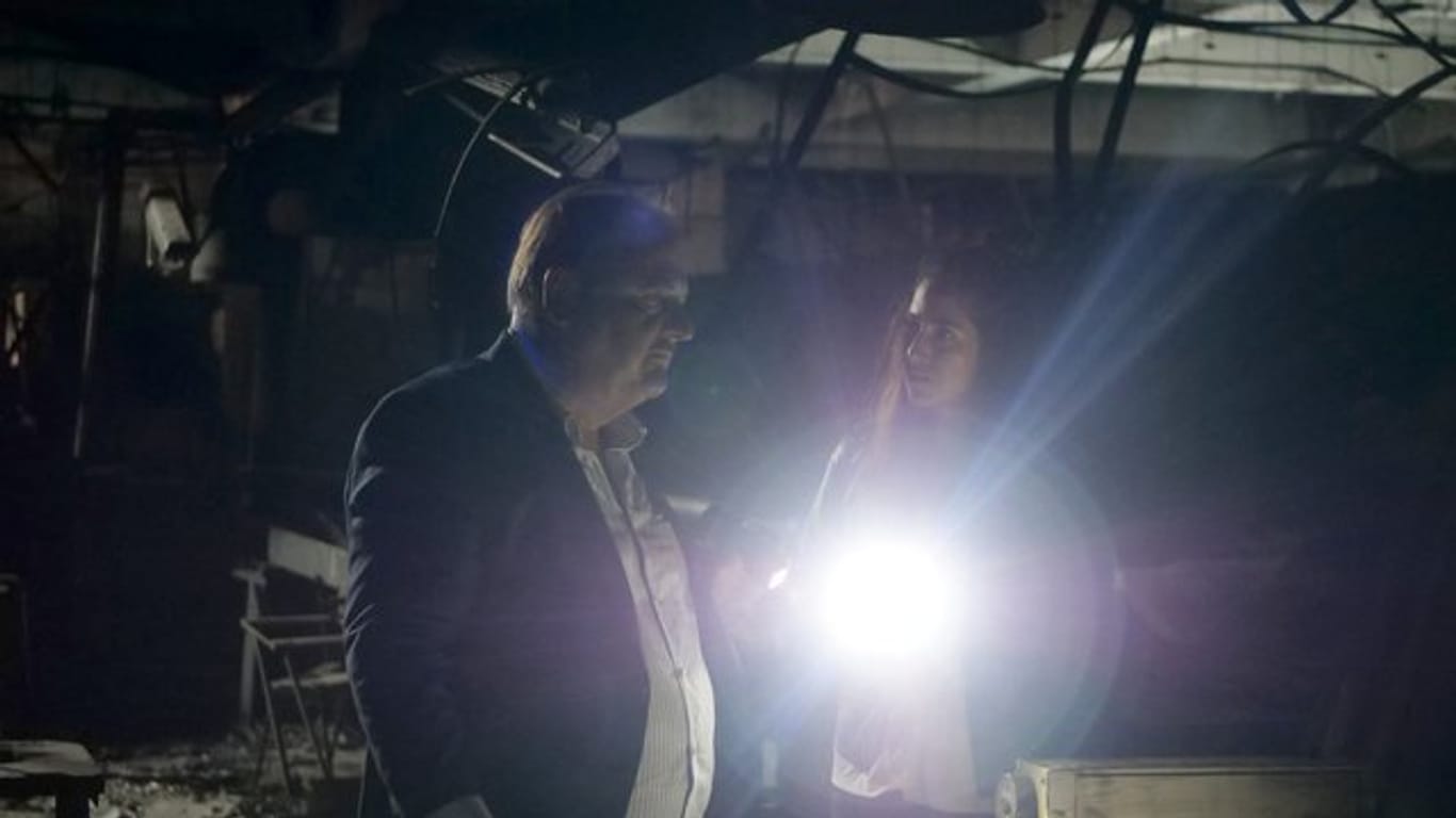 Rechtsanwalt Eduardo Silva (Jürgen Tarrach) und seine Assistentin Marcia Amaya (Vidina Popov) suchen in der zerstörten Kleiderfabrik nach neuen Beweisen.