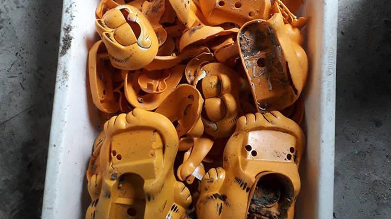 Telefone in Form der Comic-Katze Garfield liegen in einem Korb: Jahrzehntelang sind an den Stränden der Bretagne orangefarbene Telefone angespült worden.