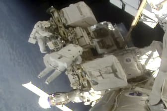 Die Astronauten Nick Hague und Christina Koch schweben an der Raumstation ISS im Weltall.