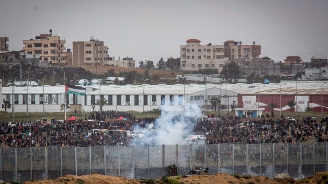 Soldaten der israelischen Streitkräfte feuern von der israelischen Seite der Grenze zwischen Israel und Gaza Tränengas auf palästinensische Demonstranten. Soldaten der israelischen Streitkräfte feuern von der israelischen Seite der Grenze zwischen Israel und Gaza Tränengas auf palästinensische Demonstranten.