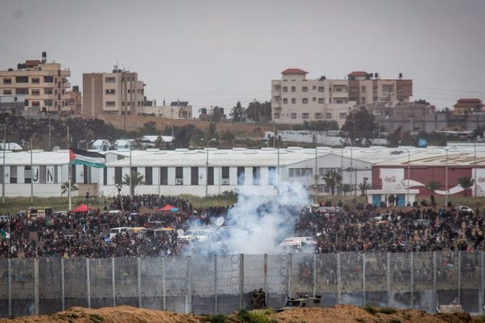 Soldaten der israelischen Streitkräfte feuern von der israelischen Seite der Grenze zwischen Israel und Gaza Tränengas auf palästinensische Demonstranten.