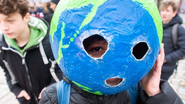 Bei einer "Fridays for Future"-Kundgebung hat sich ein Schüler mit einer Weltkugel aus Pappmache ausgestattet. Bei einer "Fridays for Future"-Kundgebung hat sich ein Schüler mit einer Weltkugel aus Pappmache ausgestattet.