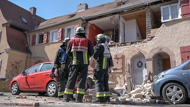 Feuerwehrleute stehen vor einem Haus in Nürnberg, dessen Fassade teilweise weggesprengt wurde. Feuerwehrleute stehen vor einem Haus in Nürnberg, dessen Fassade teilweise weggesprengt wurde.