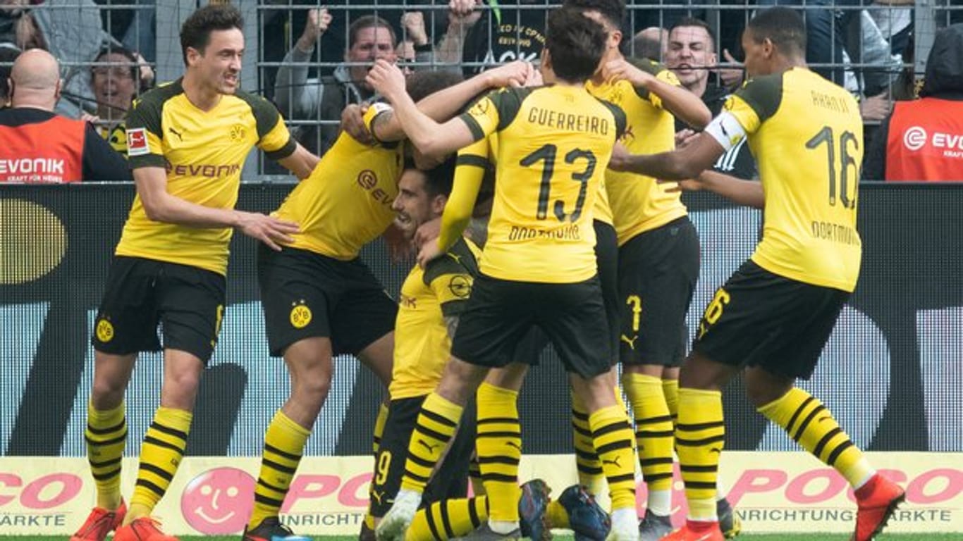 Dortmunds Paco Alcácer (knieend) wird von seinen Mitspielern für seinen späten Treffer zum 1:0 gefeiert.